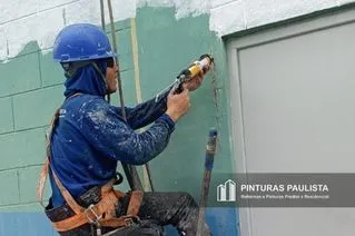 Pintor pendurado em cordas aplicando Poliuretano para restauração de uma fissura na fachada